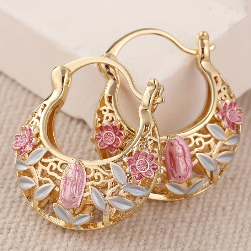 Gold hoop earrings with floral and leaf designs on a beige background